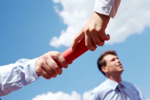 Photo of business people hands passing baton during race